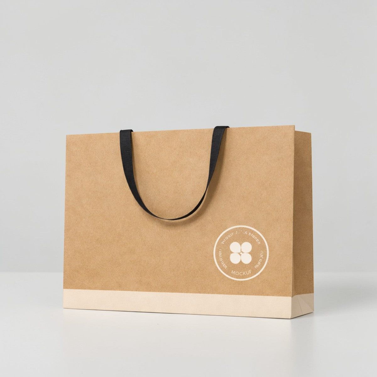 Stockka wide kraft paper gift bag with reinforced base and flat fabric handles, natural brown.