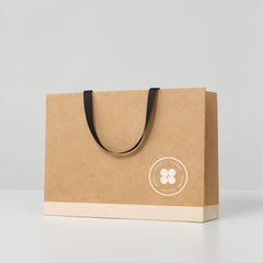 Stockka wide kraft paper gift bag with reinforced base and flat fabric handles, natural brown.