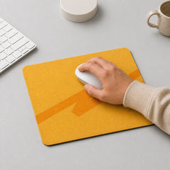Stockka yellow felt mouse pad with orange geometric design. A hand uses a white mouse on the pad.